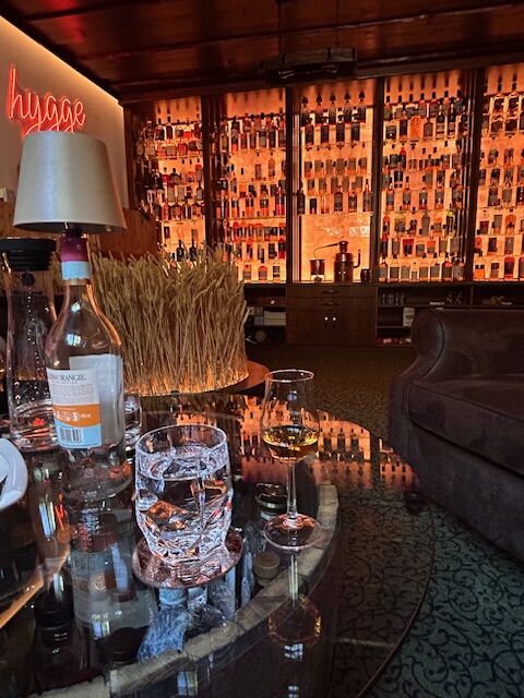 Whiskyglas und Flasche auf Fasstisch